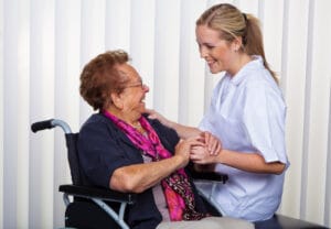Nurse sitting next to lady in wheelchair